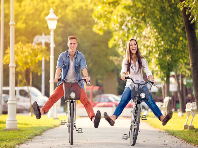 Casal andando de bicicleta em parque