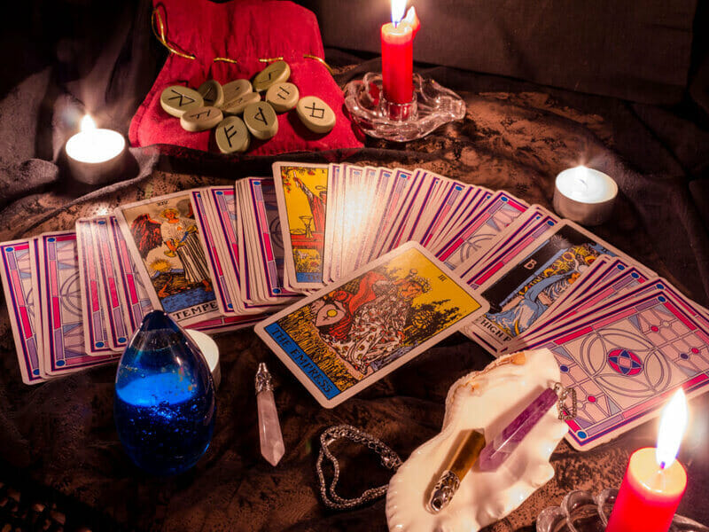 Mesa de madeira com velas e cartas de tarot