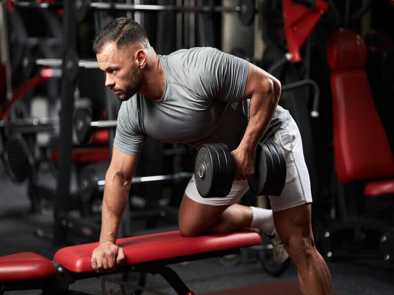 Homem em uma academia fazendo musculação