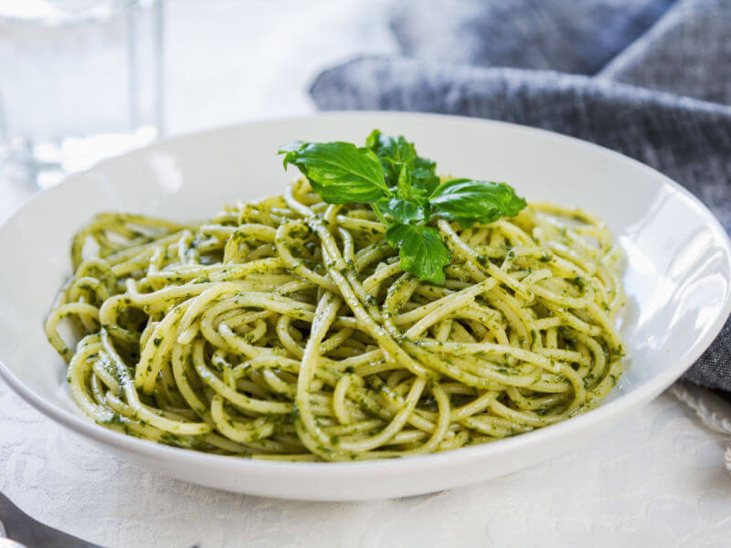 Macarrão ao molho pesto em prato branco