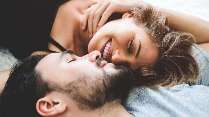 Homem e mulher deitados sorrindo