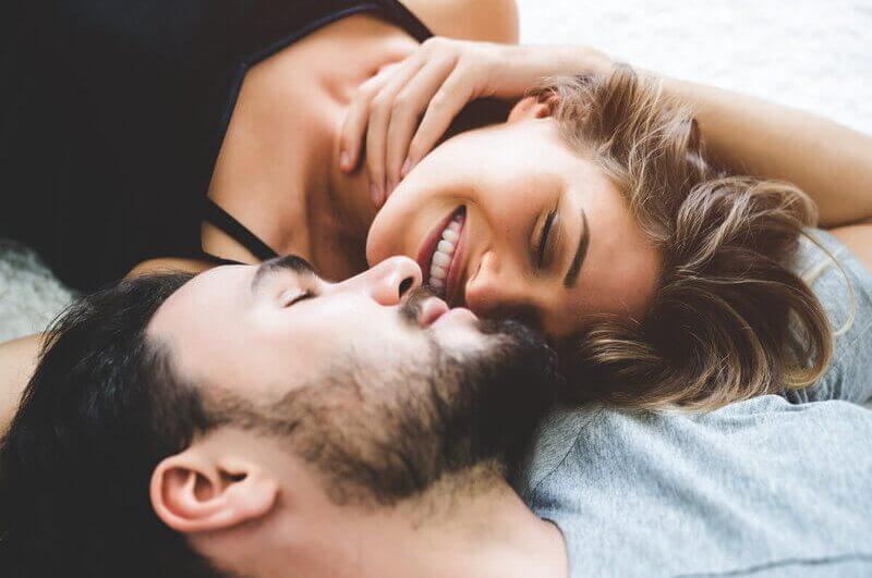 Homem e mulher deitados sorrindo