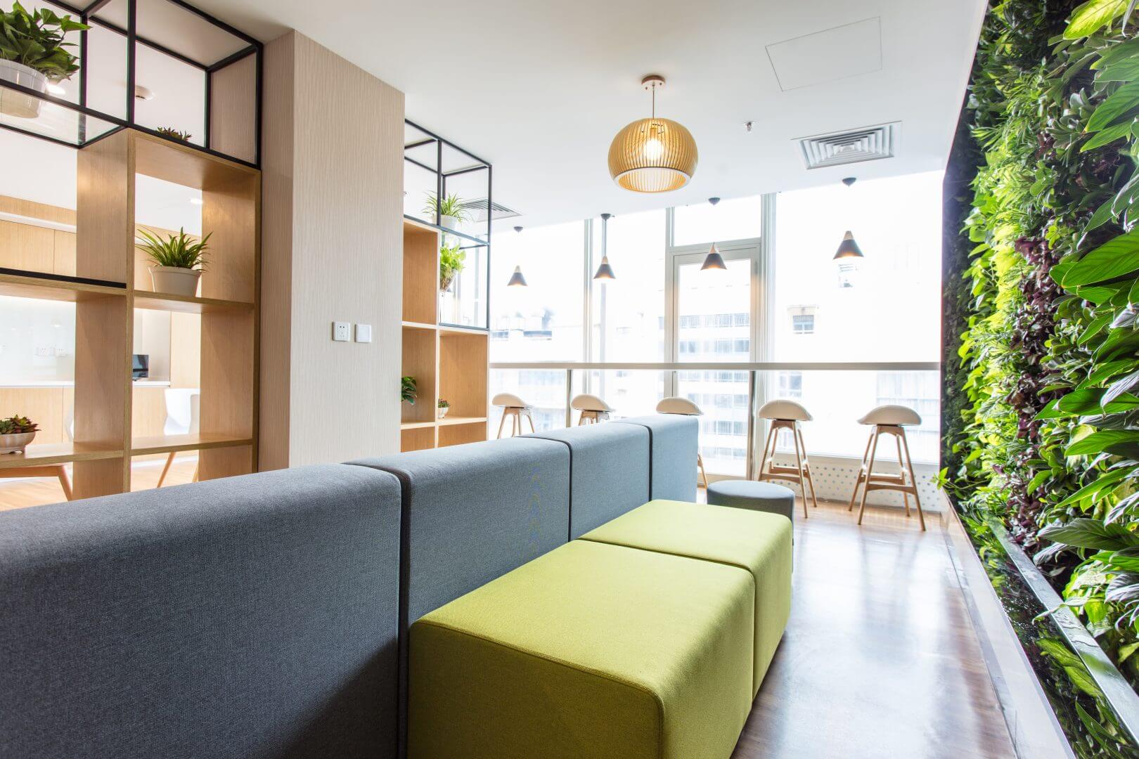 Sala de empresa com plantas e sofás coloridos