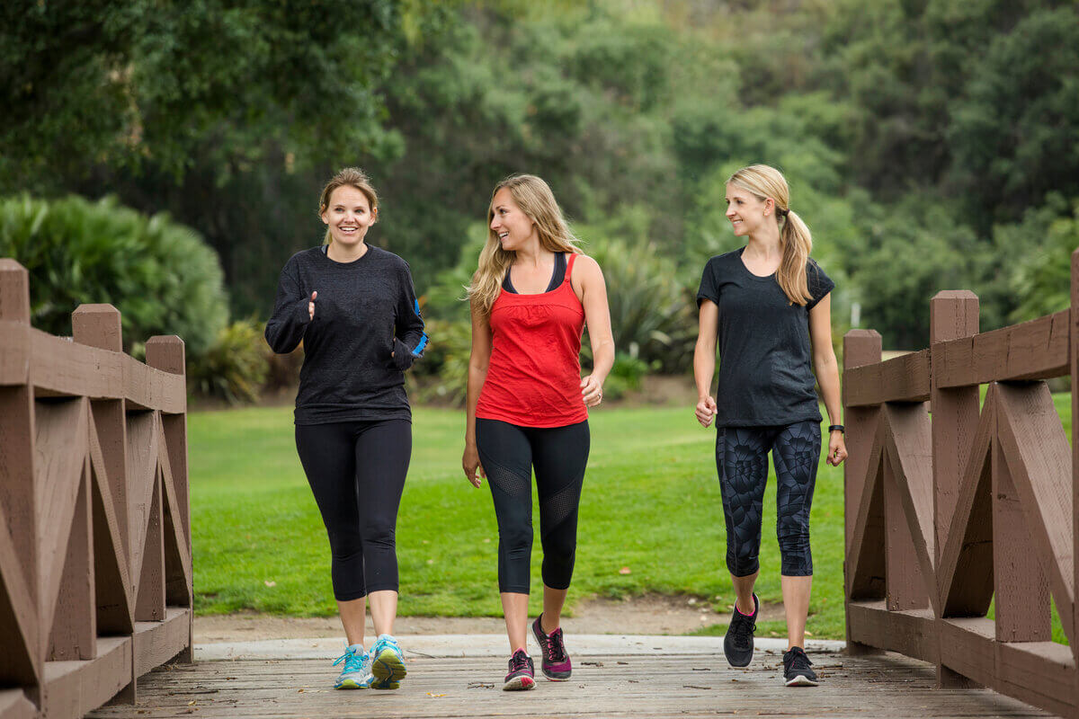 Três mulheres caminhando em um parque