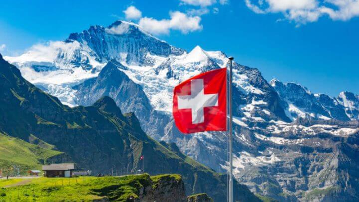 Bandeira da Suíça com Alpes de fundo