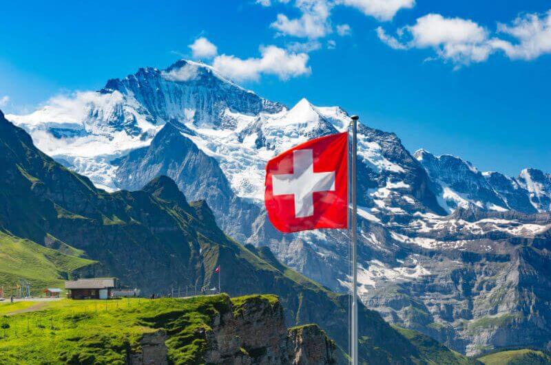 Bandeira da Suíça com Alpes de fundo
