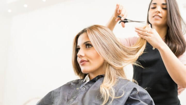 Cabeleireira cortando cabelo de mulher