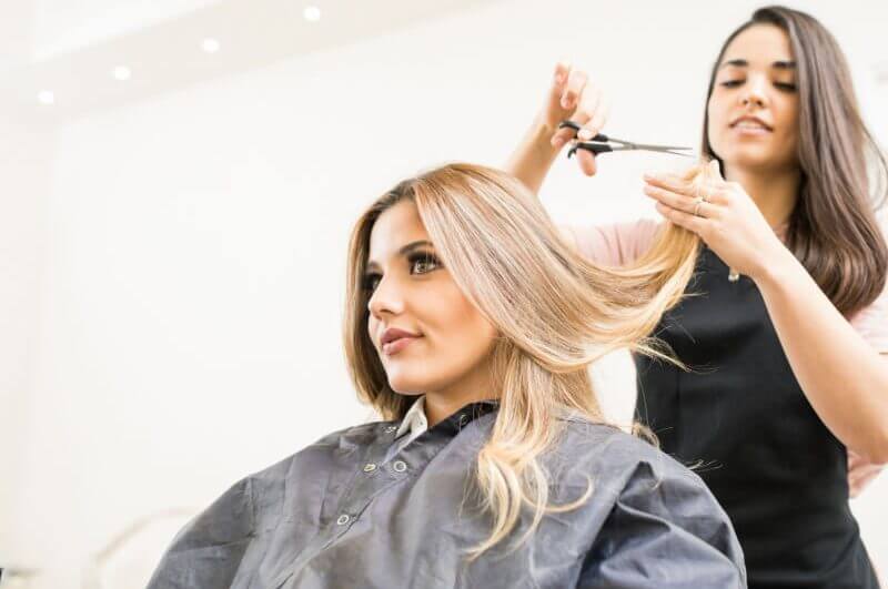 Cabeleireira cortando cabelo de mulher