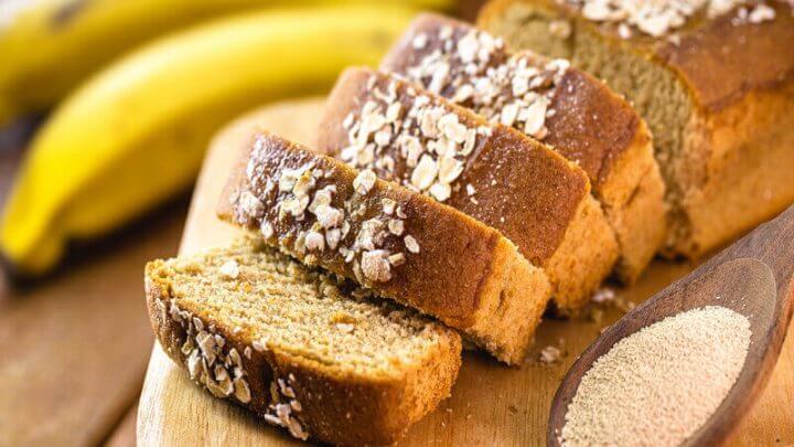 Bolo de banana cortado em pedaços em cima de uma tábua de madeira