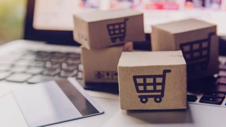 caixas de papel ou pacote com o logotipo do carrinho de compras e cartão de crédito no teclado do laptop