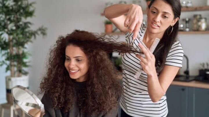 Cabeleireira cortando cabelo da cliente