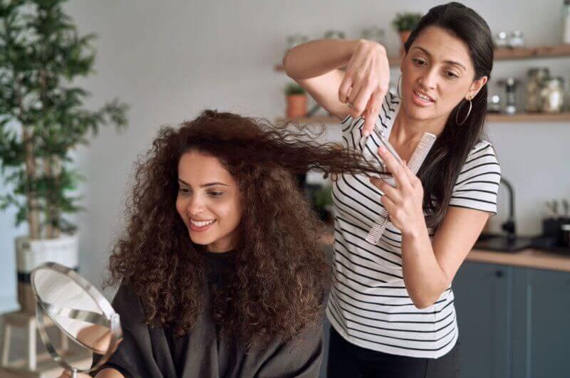 Cabeleireira cortando cabelo da cliente