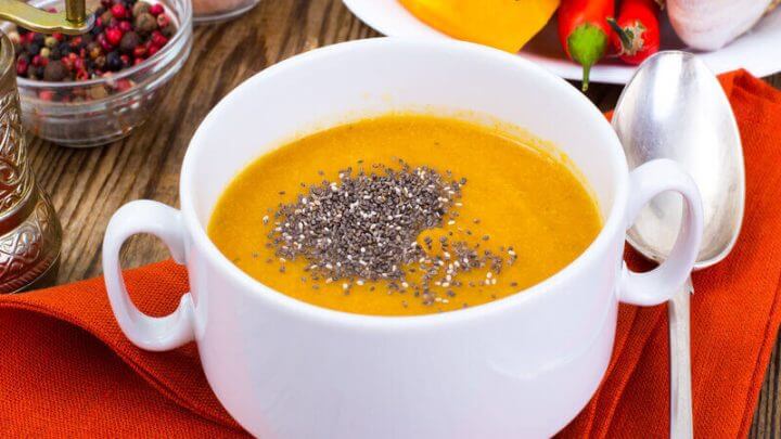 Creme de abóbora em uma panela branca com sementes de chia
