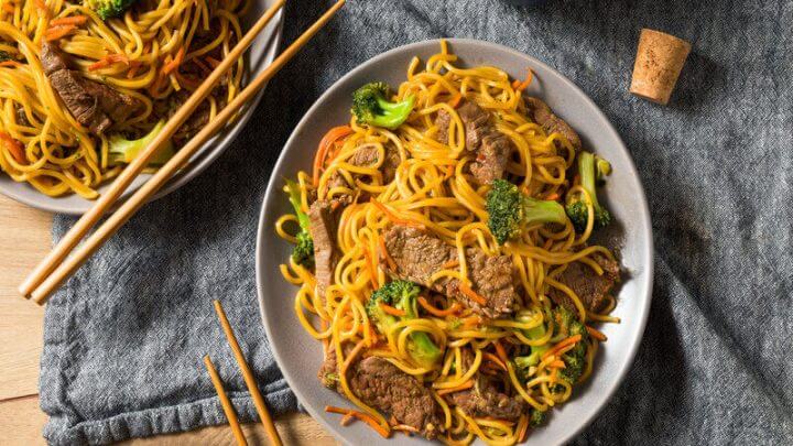 Prato cinza com yakisoba de carne com brócolis e cenoura