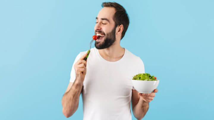 Comendo de blusa branca comendo salada