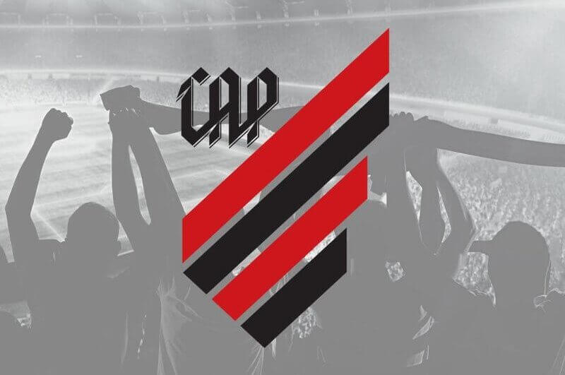 Logo do time Athletico Paranaense em frente a imagem de uma torcida em estádio