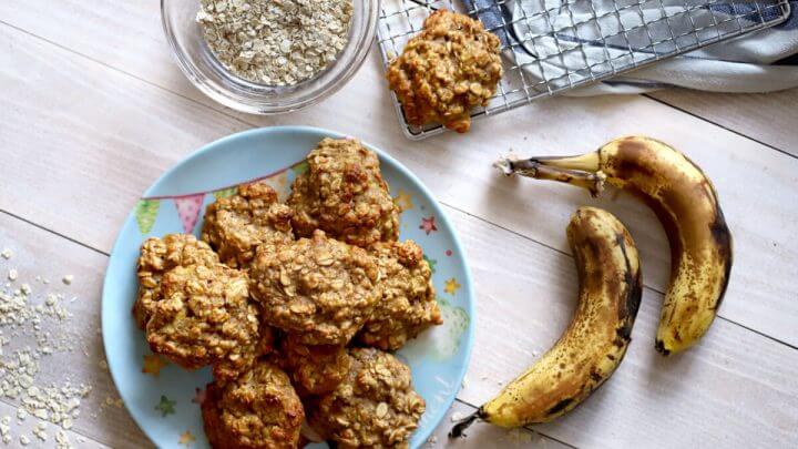 Biscoito de aveia em um prato azul com duas bananas em volta