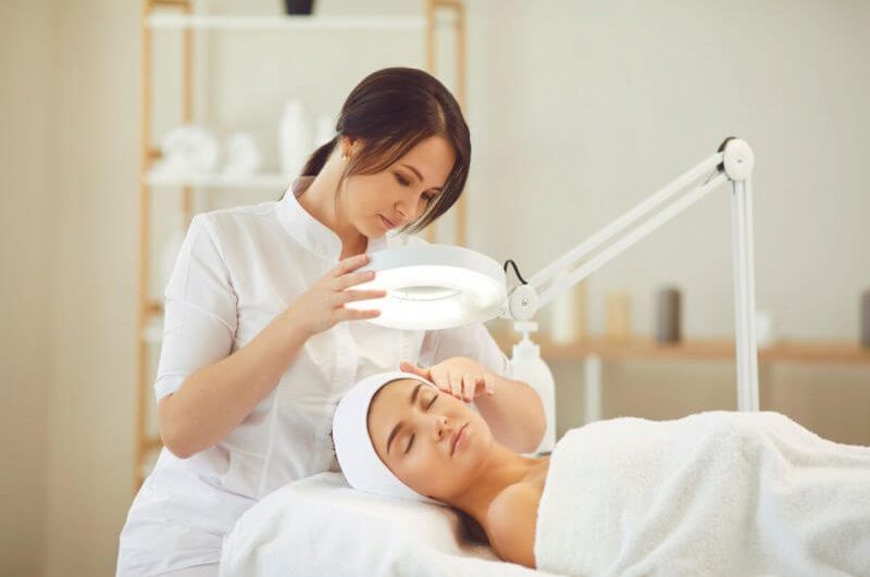 Médica dermatologista analisando o rosto de uma paciente