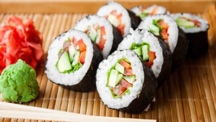 Sushis com pepino e tomate em cima de um tapete de bambu