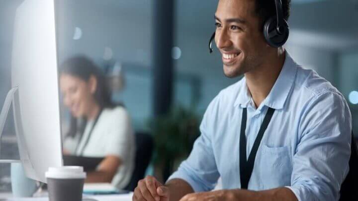 Homem sentado usando headfone e mexendo no computador