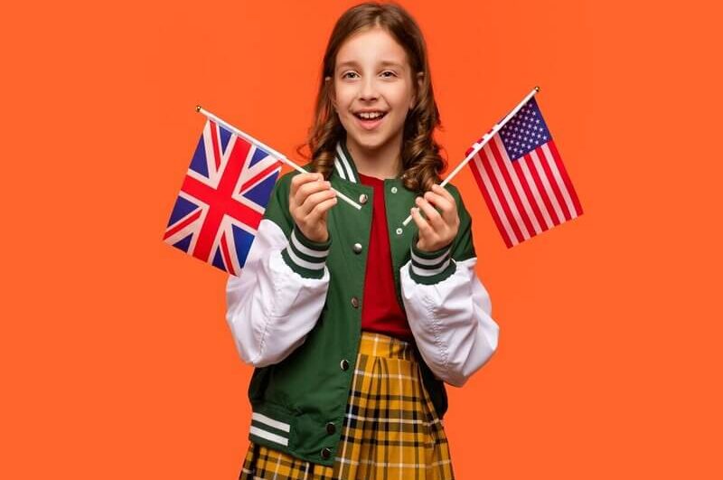 Menina sorrindo segurando a bandeira dos Estados Unidos e do Reino Unido