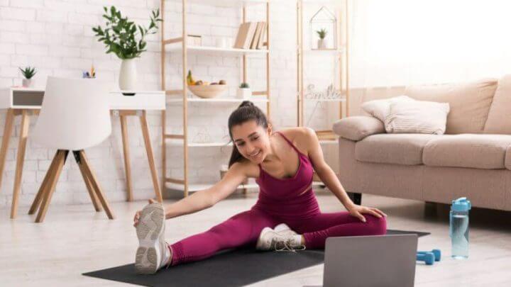 Mulher se exercitando em casa com aulas online