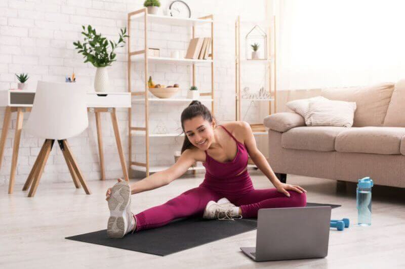 Mulher se exercitando em casa com aulas online