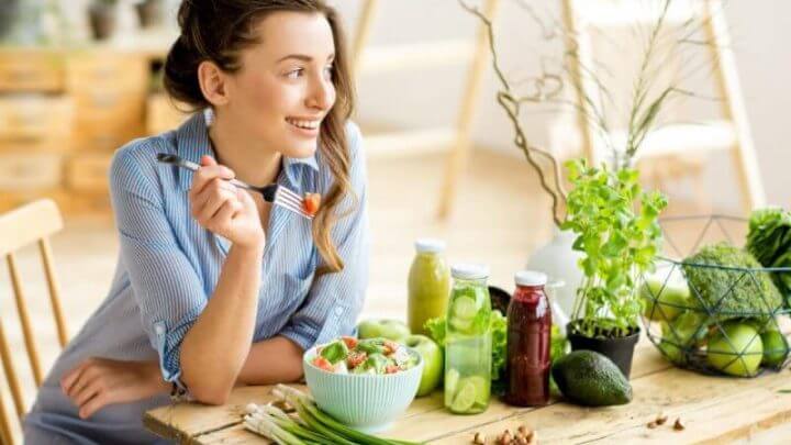 Mulher jovem comendo salada