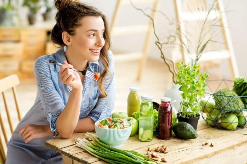Mulher jovem comendo salada