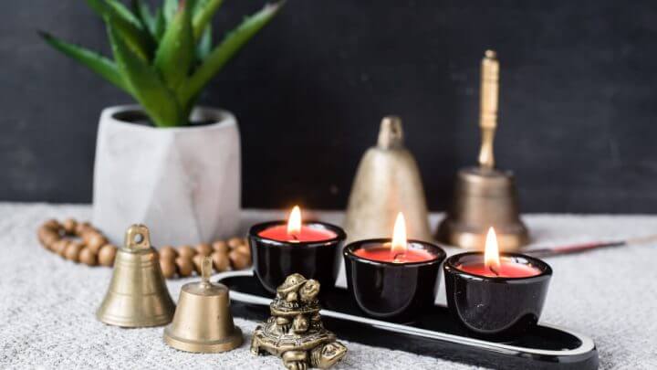 Composição com símbolos budistas e feng shui: yin yang, tartarugas, velas aromáticas, rosários, sinos de mão e planta em vaso