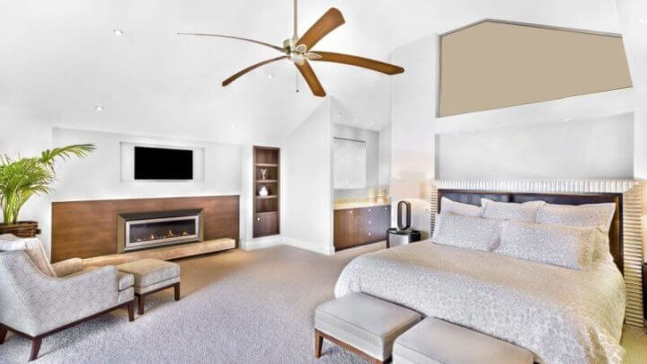 Quarto moderno, com parede clara, incluindo móveis, televisão anexada à parede, uma cadeira perto de vaso de flores, ventilador no teto, mesa de lâmpada