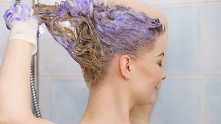 Mulher aplicando shampoo matizador no cabelo