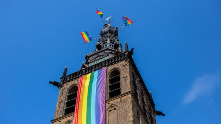Bandeiras do arco-íris na frente e no topo da Igreja na Holanda.