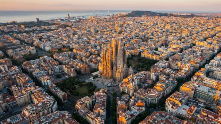 Visão aérea do distrito residencial Eixample de Barcelona e da Basílica da Sagrada Família ao amanhecer.
