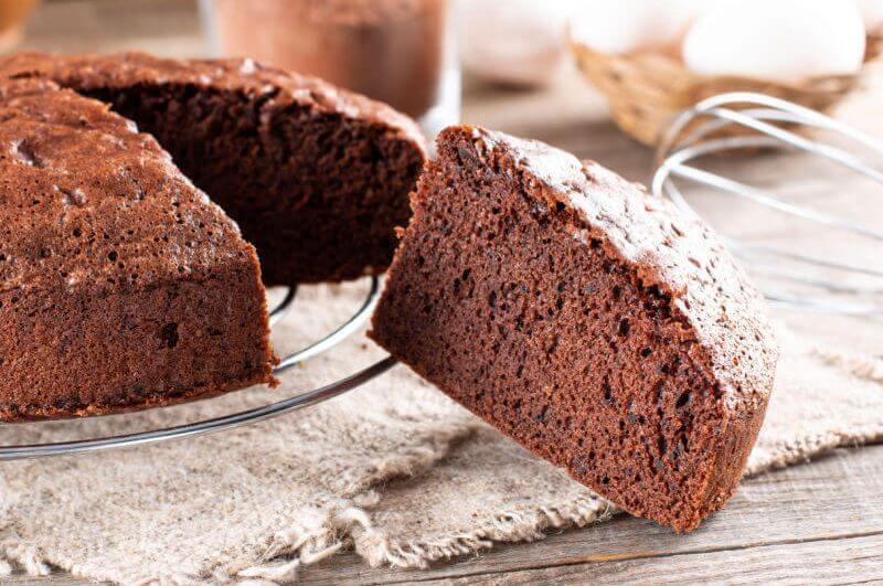 Fatia de bolo de chocolate ao lado de bolo inteiro