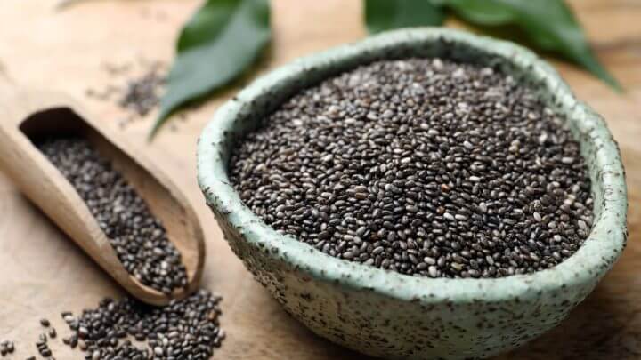 Bowl cheio com sementes de chia e sementes espalhadas ao lado