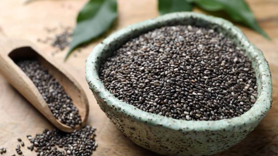 Bowl cheio com sementes de chia e sementes espalhadas ao lado