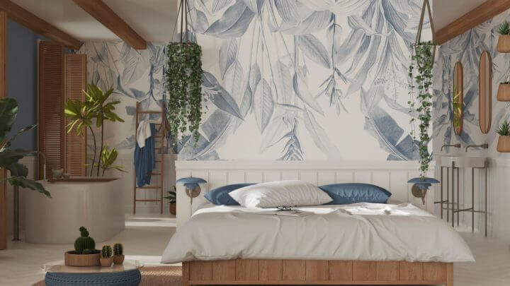 Quarto grande decorado com tons brancos e azuis, plantas ao redor e papel de parede de folhas,