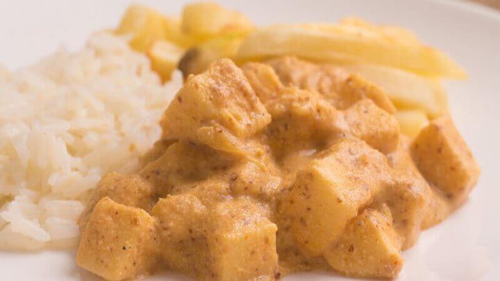 Estrofonofe de palmito em um prato branco com arroz e batata-frita