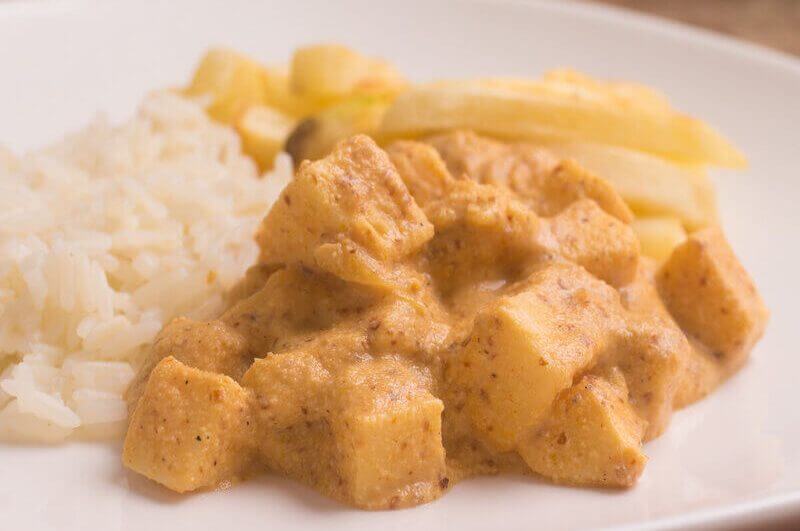 Estrofonofe de palmito em um prato branco com arroz e batata-frita