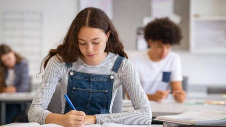 Estudante fazendo anotações do livro para seu estudo