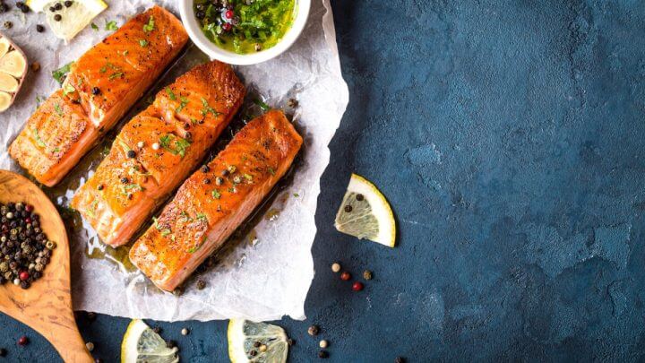 Salmão assado com crosta de ervas em cima de concreto rústico azul