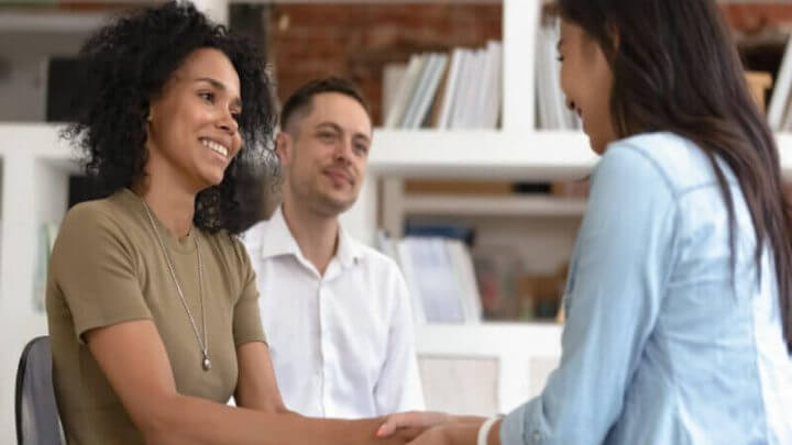 Mulheres de mãos dadas durante a sessão de terapia de grupo