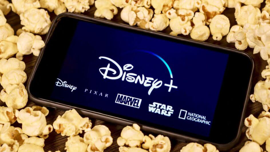 Celular com imagem da Disney+ com várias pipocas ao redor