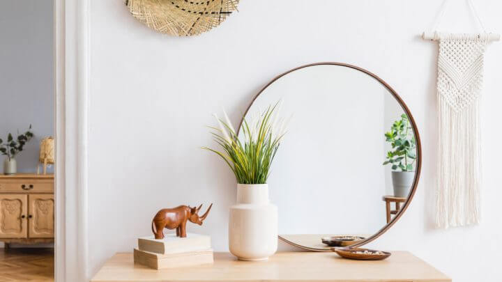 Mesa com objetos decorativos: espelho, vaso, rinoceronte e outros