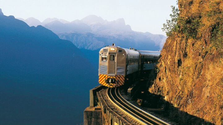 Trem em linha com montanhas ao fundo