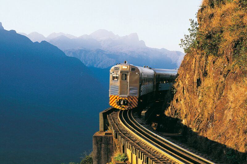 Trem em linha com montanhas ao fundo