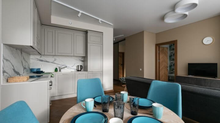 Interior de uma sala de estar com cozinha integrada em um pequeno apartamento