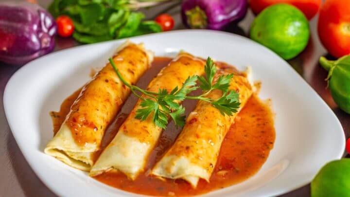 Prato com três panquecas com molho de tomate