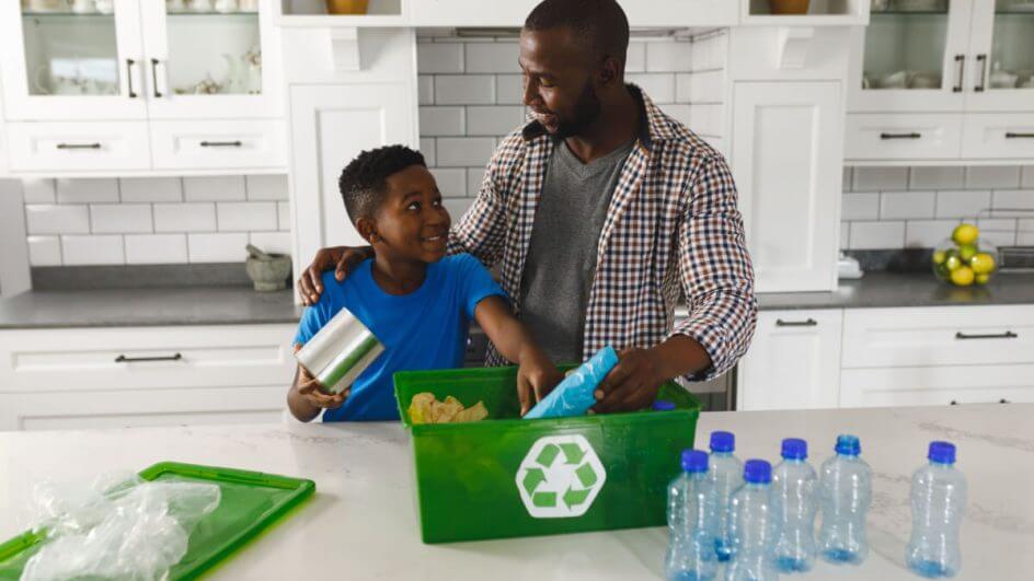 Pai e filho na cozinha conversando e separando lixo para reciclagem
